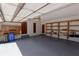 Well-lit garage with ample storage featuring built-in cabinets, shelving, and a freshly painted floor at 4428 Sugartree E Dr, Lakeland, FL 33813