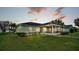 Screened patio and solar panels, surrounded by a lush green lawn at 7454 Briarbay Loop, Lakeland, FL 33810
