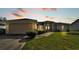 House exterior at dusk showcasing a two-car garage and landscaping at 7454 Briarbay Loop, Lakeland, FL 33810