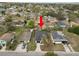 Aerial view of a one-story home, showcasing the roof, driveway, yard, and surrounding neighborhood at 1217 Avenue J, Haines City, FL 33844