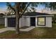 Charming single-story home featuring a black garage door and door, complemented by a well-manicured front yard and landscaping at 1217 Avenue J, Haines City, FL 33844