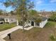Aerial view of a white single-story home with a dark roof, showcasing the driveway, mailbox and front yard at 1217 Avenue J, Haines City, FL 33844