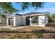 Stylish single-story home featuring a black garage door and door, complemented by a tidy front yard and landscaping at 1217 Avenue J, Haines City, FL 33844