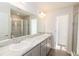 Bright bathroom featuring a double sink vanity with a marble countertop and glass-enclosed shower at 2214 Oldham Ct, Haines City, FL 33844
