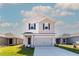 Charming two-story home featuring a gray facade, black shutters, and a two-car garage at 2214 Oldham Ct, Haines City, FL 33844