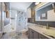 Updated bathroom with a gray vanity, marble countertop, and walk-in shower at 17 Loma Verde # 17, Lakeland, FL 33813