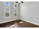 This bedroom features wood floors, three windows, and white trim throughout at 5074 Shore Side Dr, Lakeland, FL 33812