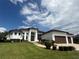 Beautiful single-story home featuring manicured lawn, an arched entryway, and a three-car garage at 5074 Shore Side Dr, Lakeland, FL 33812