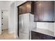 Kitchen featuring stainless steel refrigerator, dark wood cabinets and granite countertops at 5074 Shore Side Dr, Lakeland, FL 33812