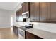 Kitchen featuring stainless steel appliances, white backsplash, and dark wood cabinets at 5074 Shore Side Dr, Lakeland, FL 33812