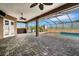 Covered patio with brick flooring and screened pool area at 5074 Shore Side Dr, Lakeland, FL 33812
