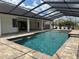 Beautiful screened-in pool area with fountains, a spa, and a covered patio area at 5074 Shore Side Dr, Lakeland, FL 33812