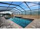 A view of the screened-in pool with spa and brick-paved deck provides a serene backyard oasis at 5074 Shore Side Dr, Lakeland, FL 33812
