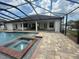 Beautiful screened-in pool and spa with brick paver patio and lush landscaping at 5074 Shore Side Dr, Lakeland, FL 33812