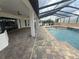Large covered patio with brick pavers overlooking a screened pool, spa, and landscaped yard at 5074 Shore Side Dr, Lakeland, FL 33812