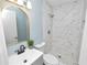 Nicely updated bathroom with a marble-tiled shower, gray vanity, and round mirror at 1220 Woodland Ave, Lakeland, FL 33801