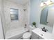 Remodeled bathroom with tub, white marble tiling, and gray vanity at 1220 Woodland Ave, Lakeland, FL 33801