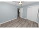 Light blue bedroom with gray floors has a ceiling fan and standard closet at 1220 Woodland Ave, Lakeland, FL 33801