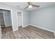 A light blue bedroom with gray floors has a ceiling fan and walk-in closet at 1220 Woodland Ave, Lakeland, FL 33801