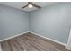 A small, clean bedroom with a ceiling fan and gray floors at 1220 Woodland Ave, Lakeland, FL 33801