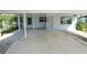 Exterior view of large carport with access door on light blue home with white columns at 1220 Woodland Ave, Lakeland, FL 33801