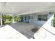 Spacious carport of light blue home with white columns and lattice and convenient access door at 1220 Woodland Ave, Lakeland, FL 33801