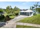 Charming single-story home featuring a covered carport and well-maintained landscaping with solar panels at 1220 Woodland Ave, Lakeland, FL 33801