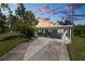 Exterior of home with large carport and driveway under colorful sky at 1220 Woodland Ave, Lakeland, FL 33801
