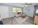 Inviting living room features a ceiling fan, a comfortable sofa, wood-look floors and great natural lighting at 1220 Woodland Ave, Lakeland, FL 33801