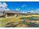 Rear of home featuring screened lanai and spacious backyard at 2256 Firestone Pl, Winter Haven, FL 33884