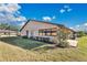 Exterior view featuring well-maintained lawn, mature landscaping, and a private back patio at 2256 Firestone Pl, Winter Haven, FL 33884