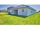Backyard view featuring a well-maintained lawn and a covered patio, great for outdoor entertaining at 4682 Grandview Glen Dr, Auburndale, FL 33823
