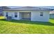 A shot of a backyard showing a well-kept lawn and covered patio with double doors at 4682 Grandview Glen Dr, Auburndale, FL 33823