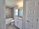 Bathroom with bathtub, gray wood look tile and granite vanity top at 4682 Grandview Glen Dr, Auburndale, FL 33823