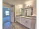 Bathroom featuring double sinks with granite countertop and wood look flooring at 4682 Grandview Glen Dr, Auburndale, FL 33823