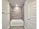 Bathroom features a sleek tub with tiled wall and modern fixtures, offering a stylish retreat at 4682 Grandview Glen Dr, Auburndale, FL 33823