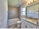 Bathroom with bathtub, shower, gray wood look tile and granite vanity at 4682 Grandview Glen Dr, Auburndale, FL 33823