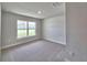 Neutral bedroom features a bright window and plush carpet, creating a serene and inviting space at 4682 Grandview Glen Dr, Auburndale, FL 33823