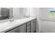 Bathroom with a double sink vanity, gray cabinets, stone countertop, and walk-in shower at 559 Sw 77Th Cir, Ocala, FL 34474