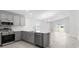 Modern kitchen with stainless steel appliances, gray cabinetry, and breakfast bar area at 559 Sw 77Th Cir, Ocala, FL 34474