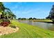 Scenic backyard view with lush greenery, a serene pond, and a clear blue sky at 3000 Sanctuary Cir, Lakeland, FL 33803