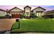 Charming two-story home with a well-manicured lawn, mailbox, and driveway leading to a two-car garage at 3000 Sanctuary Cir, Lakeland, FL 33803