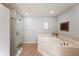Bathroom showcasing a jacuzzi tub, stand up shower, and bronze fixtures with tile floors at 5009 Hanover Ln, Lakeland, FL 33813