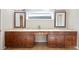 Bathroom with double sink vanity with dark wood cabinets and bronze hardware and a large mirror at 5009 Hanover Ln, Lakeland, FL 33813