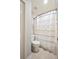 Bright bathroom featuring a white toilet and shower/tub with stylish striped curtain at 5009 Hanover Ln, Lakeland, FL 33813