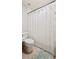 Bright bathroom with a white toilet and a shower/tub with white textured curtain at 5009 Hanover Ln, Lakeland, FL 33813