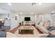 Bright living room featuring a large sofa, wood floors, and a view into the kitchen at 5009 Hanover Ln, Lakeland, FL 33813