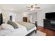 Well-lit main bedroom with dark wood accents, a ceiling fan, hardwood floors, and access to the bathroom at 5009 Hanover Ln, Lakeland, FL 33813