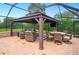 Screened-in lanai featuring a large covered gazebo, comfortable seating, and an outdoor television at 5009 Hanover Ln, Lakeland, FL 33813