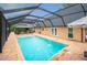 Inviting screened-in pool with water features, lounge area, and outdoor kitchen is perfect for relaxation at 5009 Hanover Ln, Lakeland, FL 33813